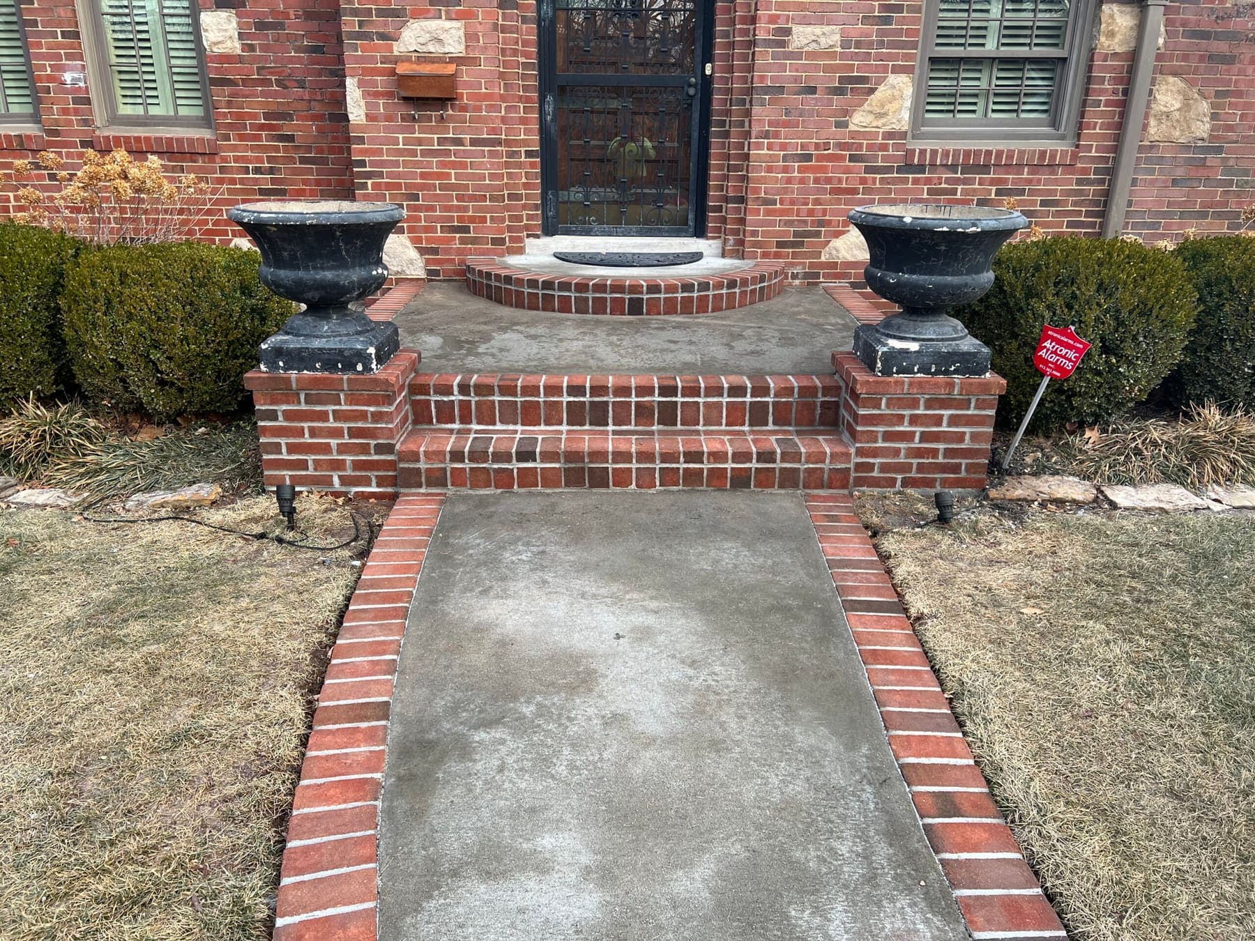 Brick front stoop with soldier-course steps and planter pedestals