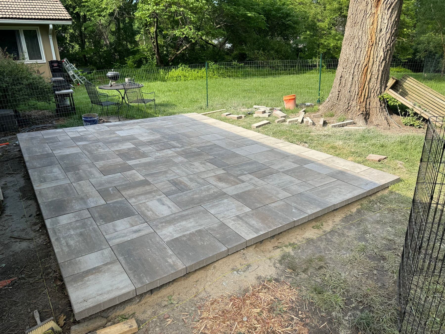 Rectangular grey and tan modular paver patio with a matching border