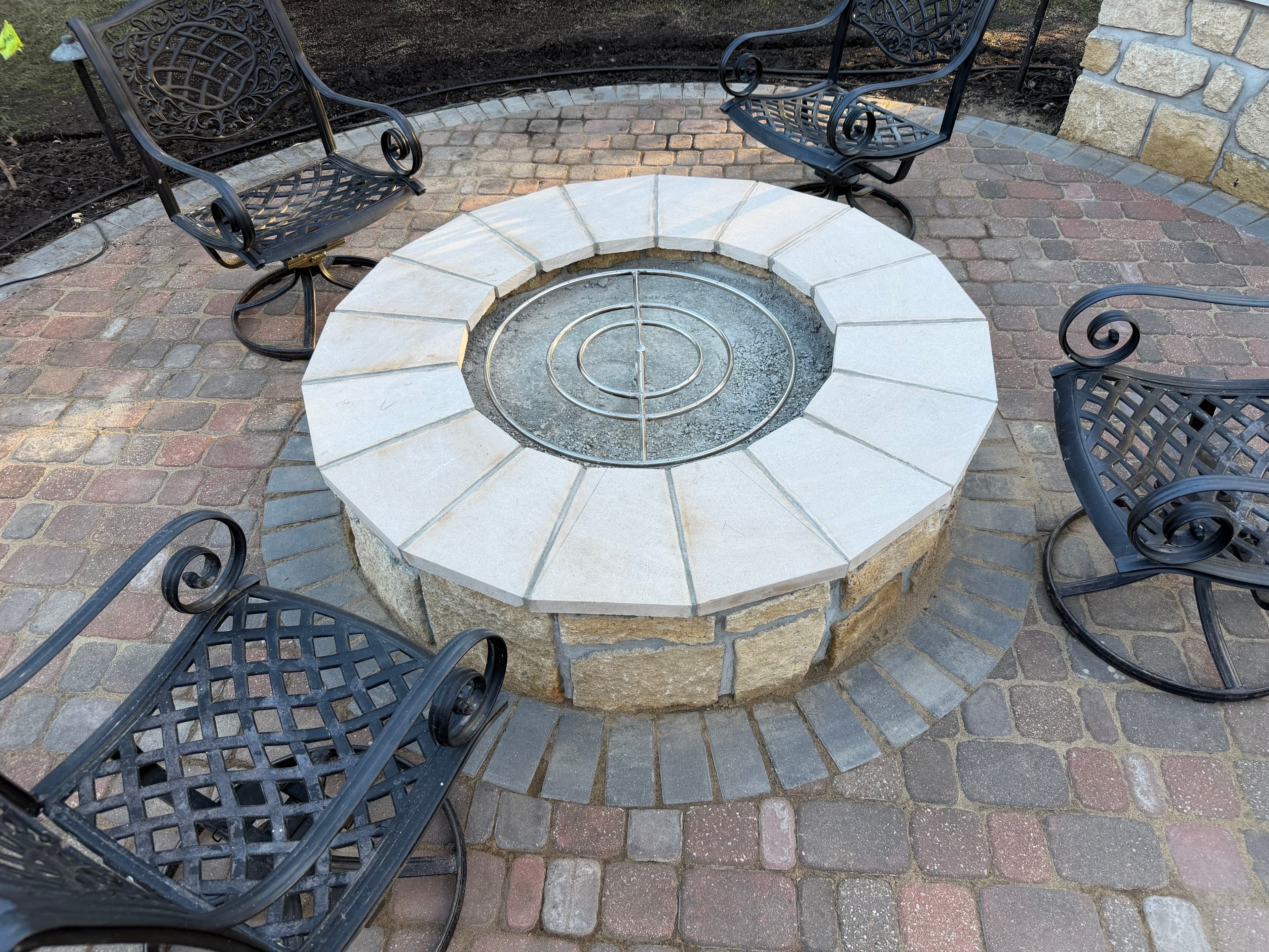 Circular stone fire pit on paver patio